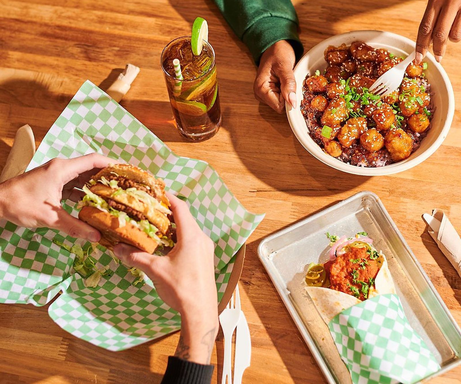 Burgers, bowls and drinks on a wooden table