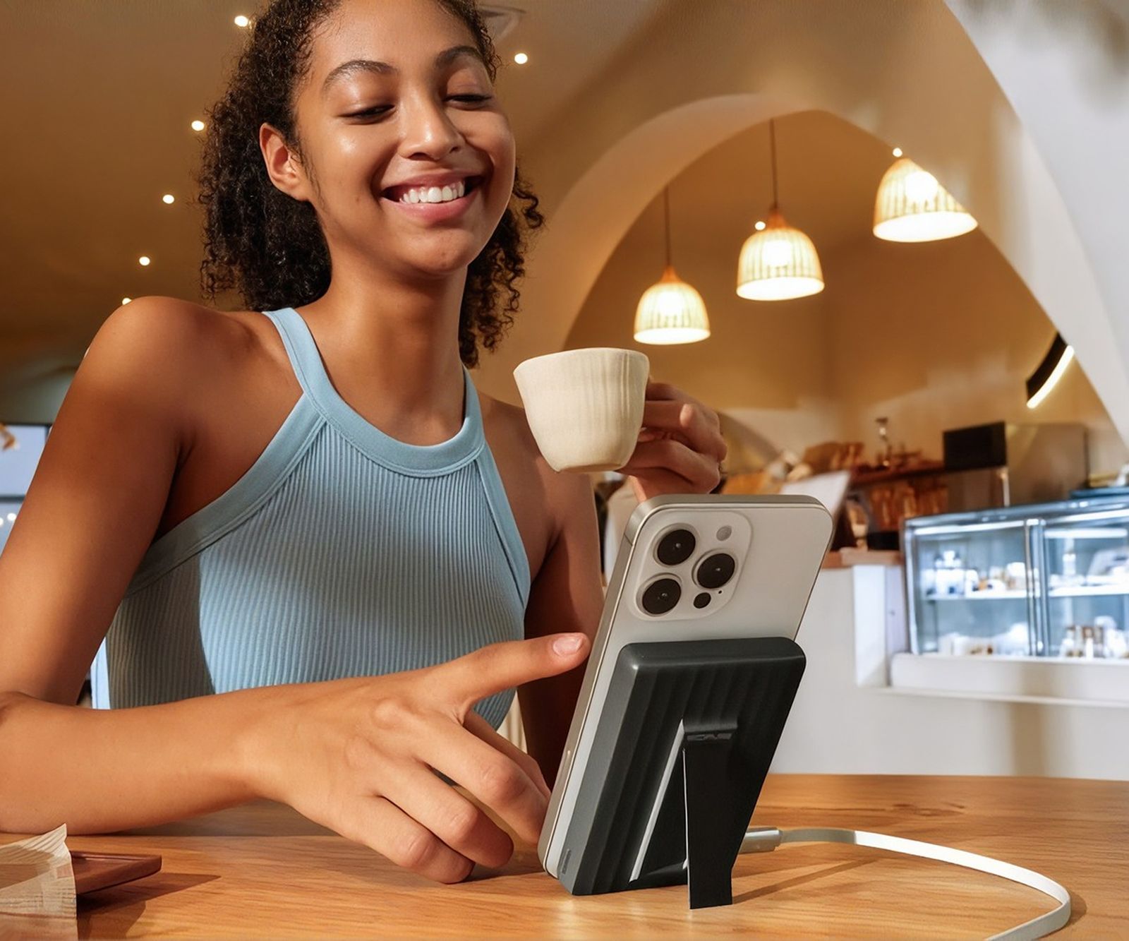 Woman with a coffee using a phone in a café